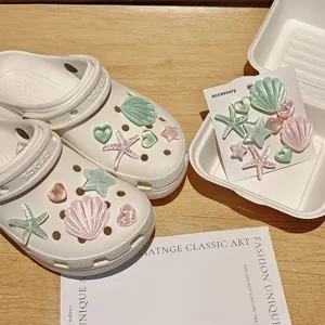 Chaussures de jardin blanches avec breloques coquillage et etoile de mer en resine, detail.
