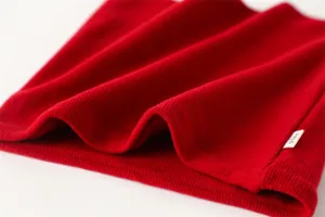 Gebreide nekwarmer detail, geribbelde textuur close-up, zachte rode winter nekwarmer