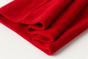 Detail van rode gebreide nekwarmer met zachte ribtextuur en warme dubbele laag.