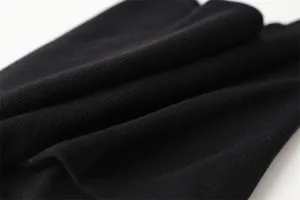 Detail van zwarte ribgebreide nekwarmer stof, met een comfortabel thermisch ontwerp voor de winter.