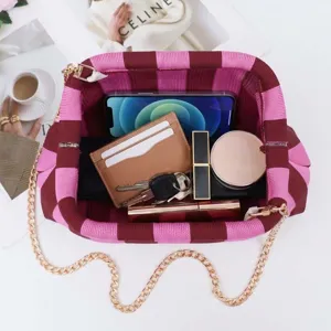 Vue détaillée de la trousse de maquillage tricotée rayée avec intérieur et chaîne.