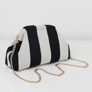 Sac pochette en tricot rayé noir et blanc avec chaîne dorée, très élégant détail.