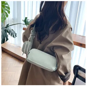 Gedetailleerd overzicht van de lichtgroene cylindrische crossbody tas met kleine tas.