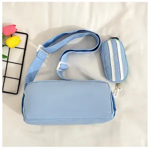 Lichtblauwe cylindrische schoudertas detail, casual minimalistische stoffen tas met klein tasje.