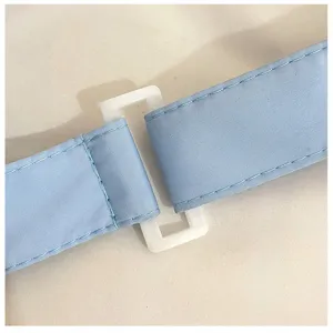 Close-up detail van de verstelbare schouderband van de crossbody tas met witte gesp.