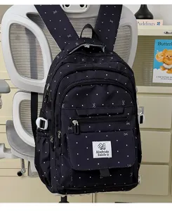Zaino blu scuro con pois bianchi e fiocchi, vista dettagliata che mostra le tasche con zip.