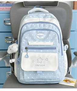 Cute blue white star patterned school backpack detail, featuring front zip pocket and plush pendant.