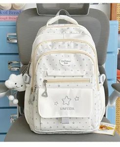 White dot school backpack detail showing front pockets, star patterns and cute cloud pendant.