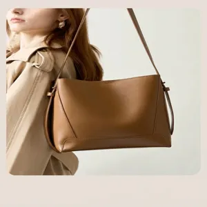 Brown leather shoulder bag side view showing sleek minimalist design and refined texture details.