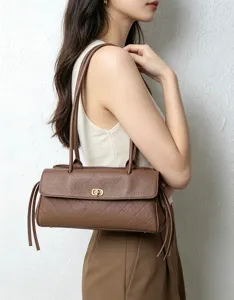 Retro brown leather shoulder bag women's baguette underarm bag with chic turn lock details.