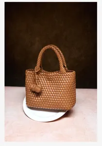 Brown woven leather handbag with top handle and knot detail for women commuting and casual use.