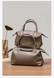 Detailed view of taupe genuine leather top-handle pillow bag with classic flap closure design.