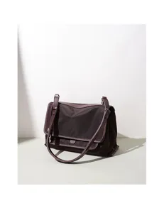 Detalle de bolso bandolera de nylon marrón oscuro, textura de bolso mensajero minimal.