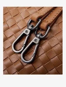 Detailed view of women's genuine leather woven shoulder bag with dark metal hardware hooks.