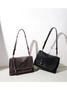 Vista detallada del bolso de hombro minimalista de nylon con solapa y dije de llave.