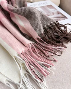 Close-up of cozy plaid winter cashmere-feel scarf with fringe tassel detail. Soft warm wrap.