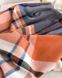 Close-up of retro orange and blue plaid imitation cashmere scarf, soft texture, winter.