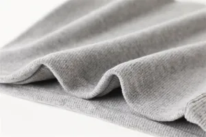 Grijze gebreide nekwarmer stof close-up detail, warme winter winddichte sjaal materiaal.