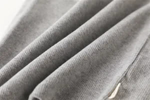 Grijze gebreide nekwarmer detailweergave, zachte thermische wintersjaal textuur close-up.
