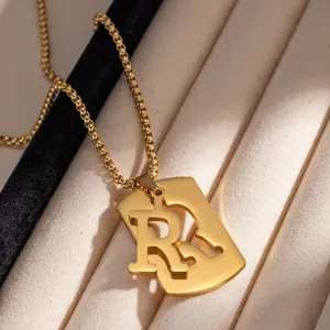 Dettaglio pendente collana con lettera R in acciaio inossidabile dorato, gioiello hip-hop.