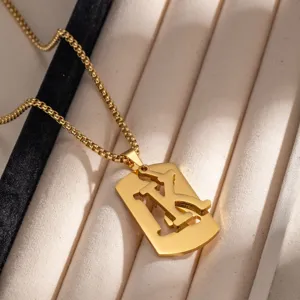 Dettaglio in primo piano di una collana con ciondolo a lettera vuota in acciaio dorato.