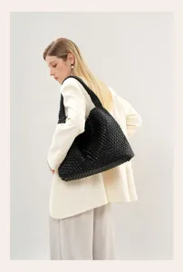 Detailed view of a stylish black woven shoulder bag, premium slouchy hobo tote design.