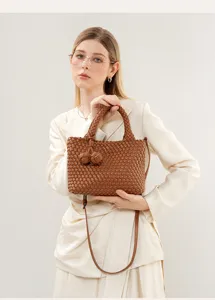 Detailed view of the brown woven leather handbag featuring elegant knot handle and shoulder strap.