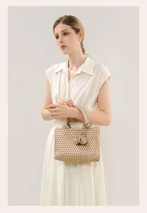 Detailed view of the luxury gold woven handbag featuring intricate craftsmanship and elegant knot.