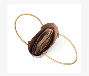 Brown leather tote bag interior detail view with spacious compartments and rope handles.
