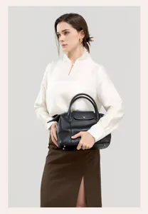 Black genuine leather top handle handbag detail showing texture, elegant style and large capacity.