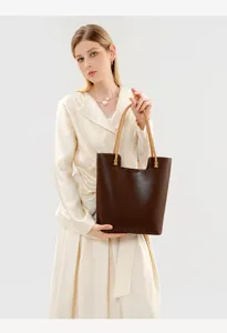 Close-up detail of premium brown leather tote bag showing fine texture and sturdy handles.