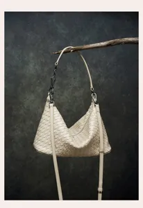 Premium woven leather hobo shoulder bag with chic metal chain accent and adjustable strap detail.