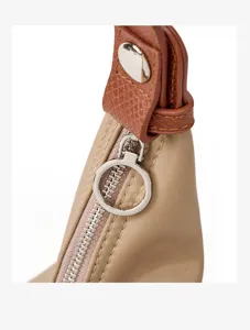 Detailed close-up view of the nylon handbag zipper and leather strap connection part.
