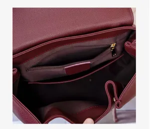 Detailed view of the burgundy leather backpack interior, showing zipper pocket and soft lining.