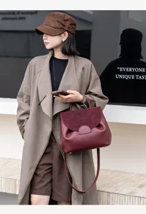 Detail view of the stylish genuine leather women handbag, elegant wine red flap crossbody bag for work.