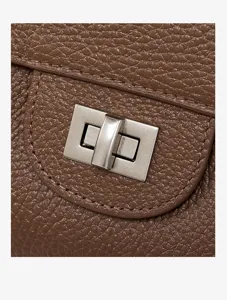 Brown leather handbag detail shot showing metallic turn lock closure and fine texture.