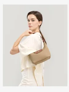 Detail view of khaki nylon shoulder bag, showing brown leather flap, handle and fine stitching.