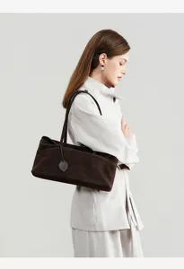 Brown suede shoulder bag detail, showcasing soft texture and elegant underarm style.