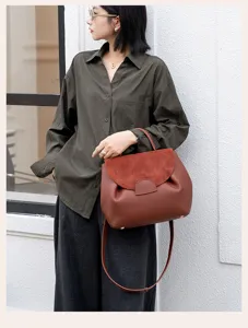 Detailed shot of the brown leather shoulder bag with stylish flap design and top handle.