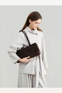 Brown suede underarm bag detail view showing soft texture and premium retro style.