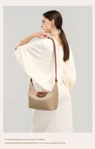 Khaki crossbody dumpling bag detail, brown leather flap and slim strap for daily commuting.