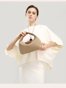 Close-up view of the nylon dumpling shoulder bag featuring a stylish brown leather flap.