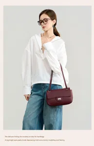 Detailed view of the dark red genuine leather shoulder bag worn by model in daily commuting scene.