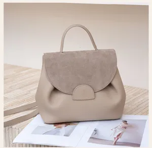 Stylish beige leather handbag with top handle and suede flap, elegant daily commuting bag.