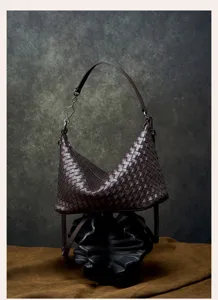 Detailed shot of dark brown woven leather hobo shoulder bag with intricate intrecciato texture