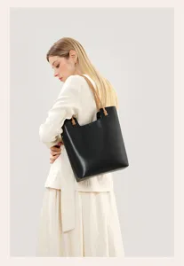 Chic black leather tote bag with brown handles, spacious minimalist shoulder bag for women.