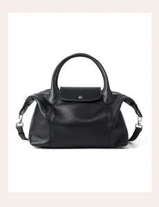 Black genuine leather top handle shoulder bag with flap closure and stylish design for women.