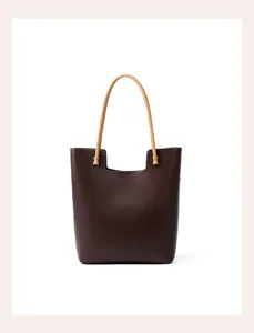 Close-up detail of premium genuine leather tote bag with contrast handle and spacious design.