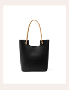 Black leather tote bag detailed view showcasing premium texture and comfortable handles.