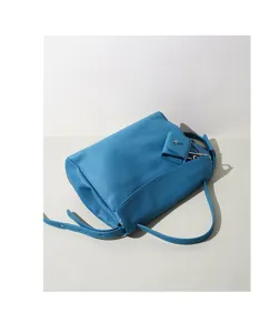 Blue leather shoulder bag detail showcasing fine pebbled texture and metal hardware.